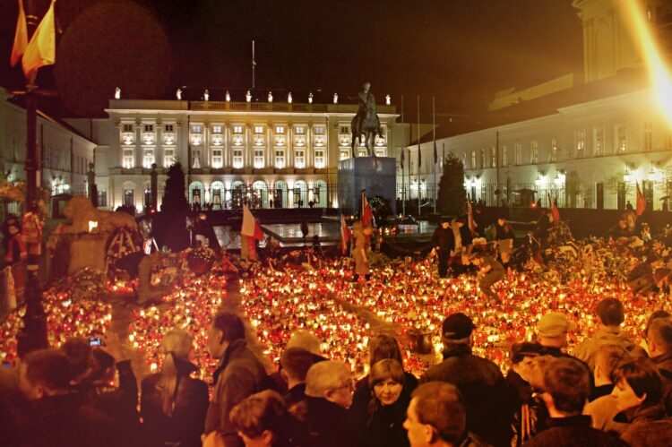 Mieszkańcy oddają hołd ofiarom katastrofy smoleńskiej przed pałacem prezydenckim na Krakowskim Przedmieściu w Warszawie. Fot. Wikimedia