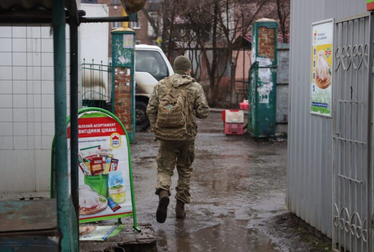 Ukraiński żołnierz opuszcza targ uliczny w małym mieście Nowy Jork, niedaleko linii frontu w pobliżu kontrolowanego przez prorosyjskich bojowników miasta Donieck na Ukrainie, 12 lutego 2022. Fot. PAP/EPA/STANISŁAW KOZLIUK